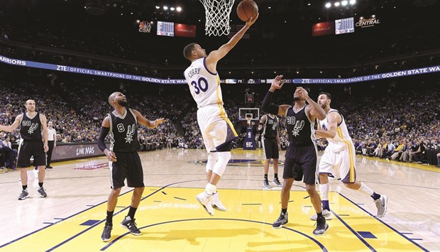 Stephen Curry of the Golden State Warriors goes up to score on a reverse layup against the San Antonio Spurs in the third quarter of their NBA game at ORACLE Arena in Oakland on Thursday.