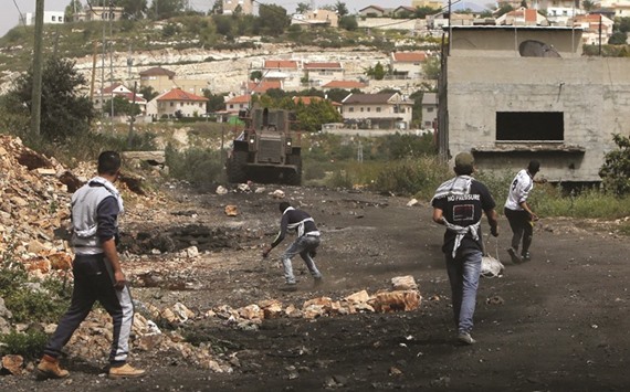 Palestinian protesters hurl stones towards Israeli security forces during clashes following a weekly demonstration against the expropriation of Palestinian land by Israel in the village of Kfar Qaddum, near Nablus, in the occupied West Bank, yesterday.
