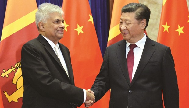 Sri Lankan Prime Minister Ranil Wickremesinghe, left, and Chinese President Xi Jinping shaking hands before their meeting at the Great Hall of the People in Beijing yesterday.