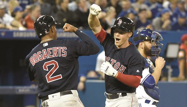 Boston Red Soxu2019s Brock Holt (centre) is greeted at home plate by Xander Bogaerts (left) after hitting a grand slam against Toronto Blue Jays yesterday. (USA TODAY Sports)