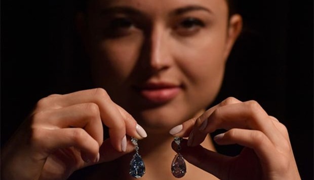 A model poses with a pair of diamond earrings during a photocall at Sotheby's auction house in London on Monday.