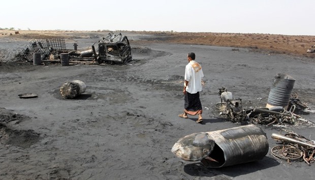 A man walks at the site of a crude oil pipeline explosion and fire near the Red Sea port of Hodeidah, Yemen, April 8, 2017