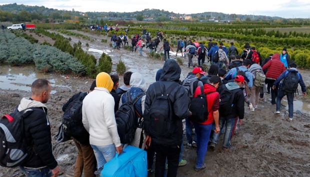 Migrants make their way after crossing the border at Zakany, Hungary