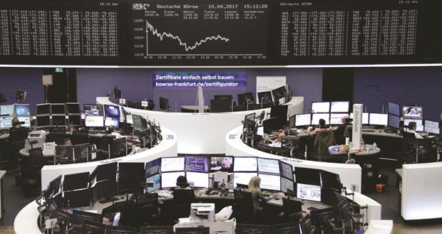 Traders work at the Frankfurt Stock Exchange. The DAX 30 closed down 0.2% to 12,200.52 points yesterday.