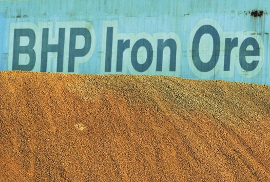 A BHP Billiton sign is seen behind a pile of iron ore at the companyu2019s loading facility in Port Hedland, Australia. Since it was set up in 2001, BHP said it had returned approximately $23bn to shareholders in buybacks and about $45bn in cash dividends. It said it had also taken many steps to increase shareholder value, cut the number of assets in its portfolio by $7bn since 2013 and cutting unit costs by more than 40%.