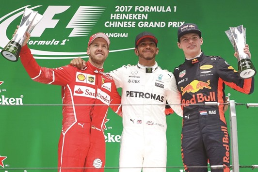 Champion Mercedes driver Lewis Hamilton of Britain celebrates on the podium with Ferrari driver Sebastian Vettel of Germany and Red Bull Racing driver Max Verstappen of the Netherlands after the Chinese Grand Prix at the Shanghai International Circuit in Shanghai. (Reuters)
