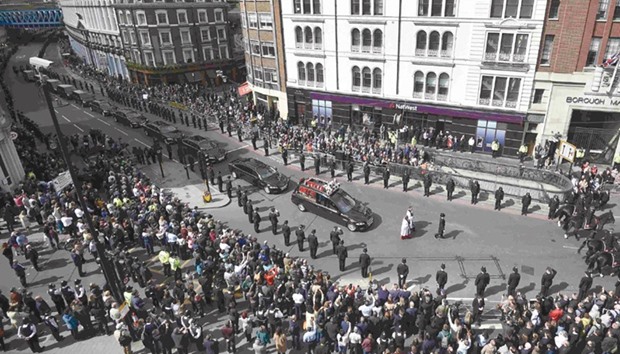Police officers line the street as the coffin of police constable Keith Palmer, who was killed in the recent Westminster attack, is transported to his funeral at Southwark Cathedral in central London yesterday.