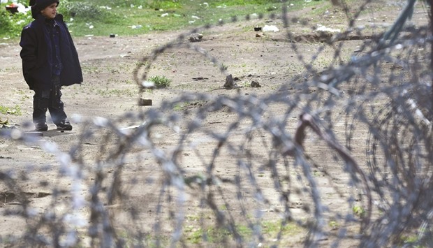 This file photo taken on April 6 shows a young migrant boy waiting in front of the Hungarian border fence at the Tompa border station transit zone. European countries must stop returning asylum-seekers to Hungary because of deteriorating conditions there for new arrivals including children, and allegations of abuse, the United Nations said.