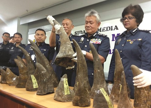 Kuala Lumpur International Airport customs director Hamzah Sundang (right) poses with rhino horns, that were seized on April 7, during a news conference at the airport in Sepang yesterday.