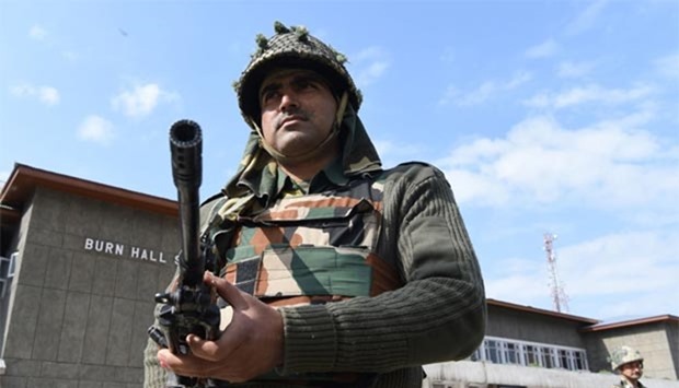 Indian paramilitary soldiers stand guard at a polling station in Srinagar on Sunday.