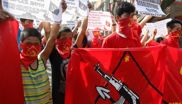 Members of an underground Communist movement march along a street in Manila
