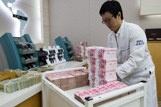 An employee arranges yuan banknotes at the Korea Exchange Bank headquarters in Seoul. China will probably let the yuan weaken further now that trade tensions with the US are receding and capital outflow pressures are easing.