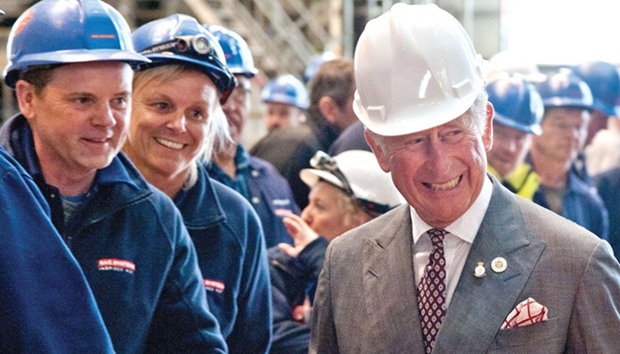 Prince Charles, Prince of Wales wears a hard hat as he talks with employees during his visit to BAE Systemsu2019 Submarinesu2019 site in Barrow in Furness, north-west England.