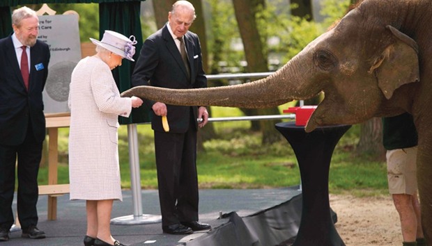 Queen Elizabeth and Prince Philip feed an elephant during a visit to Whipsnade Zoo where the queen opened the new Centre for Elephant Care, in Dunstable yesterday.