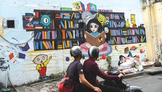 A biker rides past a work of graffiti at 3A Station, a graffiti hub and street art area in Ho Chi Minh City.
