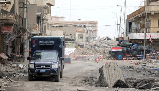 A vehicle from the Iraqi Federal Police drives along a street controlled by Iraqi forces during combat between Iraqi forces and Islamic State in Mosul.