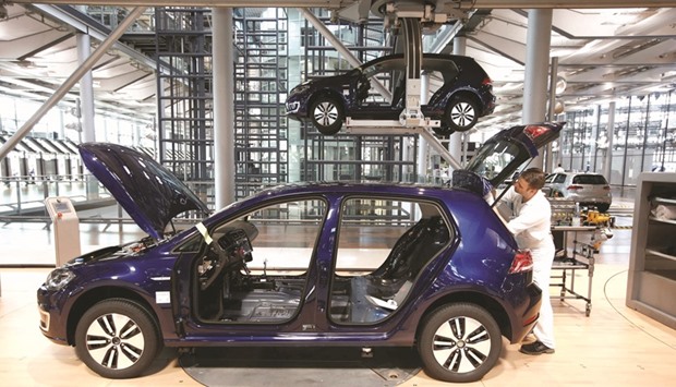 A worker assembles an electric car at a production line in Dresden, Germany. In a u20ac10bn ($10.8bn) project, Mercedes-Benz intends to release 10 new electric vehicles by 2022, three years earlier than a target announced at the Paris auto show in September.