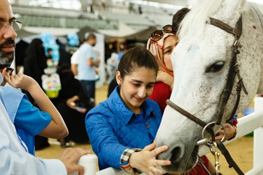 A child interacts with a horse at Al Shaqab equestrian centre.