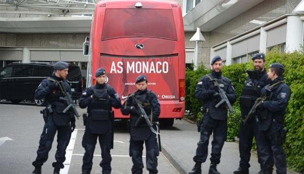 Policemen stand guard in front of a team bus of French football club