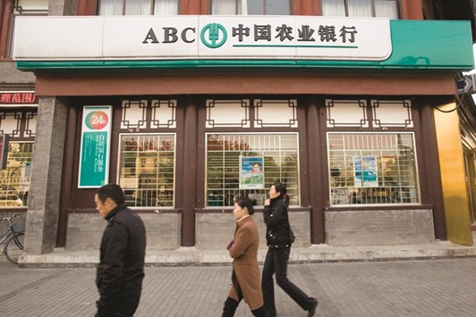 Pedestrians walk past a branch of the Agricultural Bank of China in Beijing. Chinese financial firms are trading at the biggest discount since 2004 to both the MSCI China Index and their Asian peers.