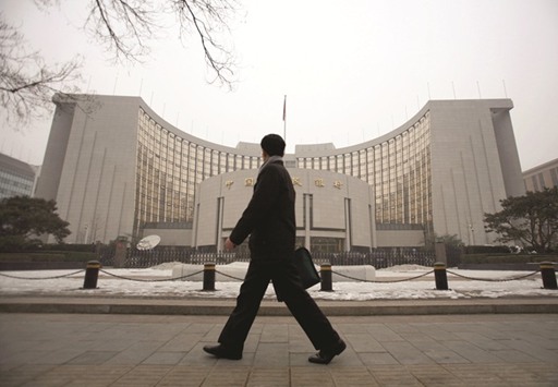 A man walks past the headquarters of the Peopleu2019s Bank of China in Beijing. Chinau2019s central bank is likely to guide market interest rates higher using reverse  repurchase agreements (repos), and its standing lending facility (SLF) and  medium-term lending facility (MLF), while keeping benchmark interest rates steady, policy advisers said yesterday.