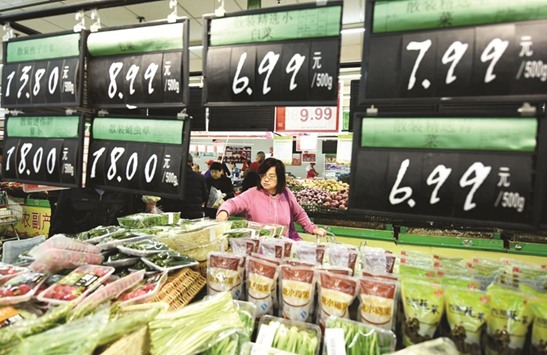 Customers select vegetables at a supermarket in Hangzhou, Zhejiang province. China is aiming for 2017 growth of around 6.5%, slightly lower than last yearu2019s target of 6.5%-7% and the actual 6.7%, which was the weakest pace in 26 years.