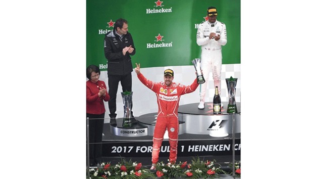 Ferrariu2019s German driver Sebastian Vettel (front) gestures after finishing second behind Mercedesu2019 British driver Lewis Hamilton (R) in the Formula One Chinese Grand Prix in Shanghai on April 9, 2017. (AFP)