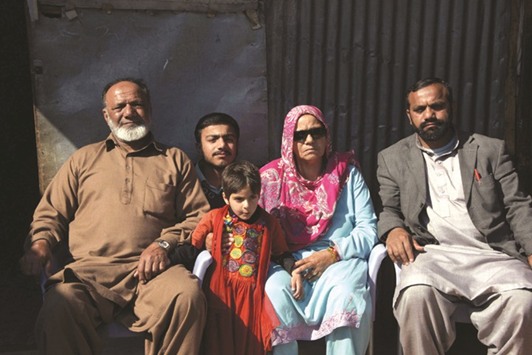 This photograph taken on February 12, 2017, shows elderly Indian Kashmiri Mohamed Ashraf (left) posing for a photograph with his wife Badar Un Nisa (second right) and son Mohamed Asghar (right) upon his arrival at a refugee camp on the outskirts of Muzaffarabad, the capital of Pakistani-administered Kashmir.