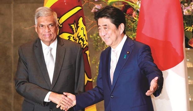 Japanese Prime Minister Shinzo Abe, right, shakes hands with Sri Lankau2019s Prime Minister Ranil Wickremesinghe at the prime ministeru2019s office in Tokyo yesterday.