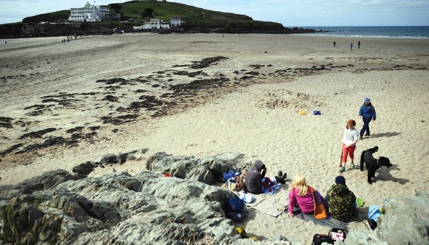 A family enjoys a day at the beach on the south coastu2019s Bigbury-on-Sea, Britain, yesterday.