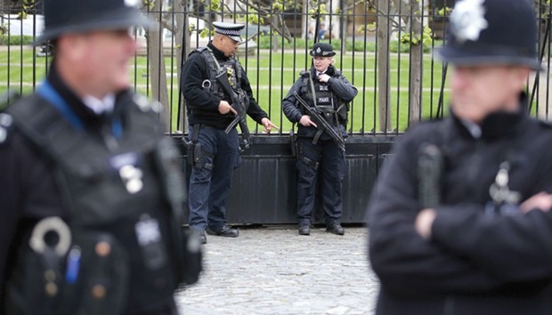 Armed police officers stand on duty inside the Carriage Gates entrance to the Houses of Parliament, within the Palace of Westminster, in central London, yesterday.