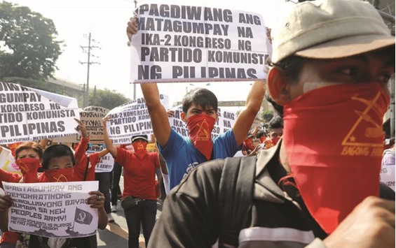 Protesters hold up placards as members and supporters of an underground Communist movement march along a street in Manila on Friday. Placards read: u201cRejoice on victory of the Second Congress of the Communist Party of the Philippines.u201d