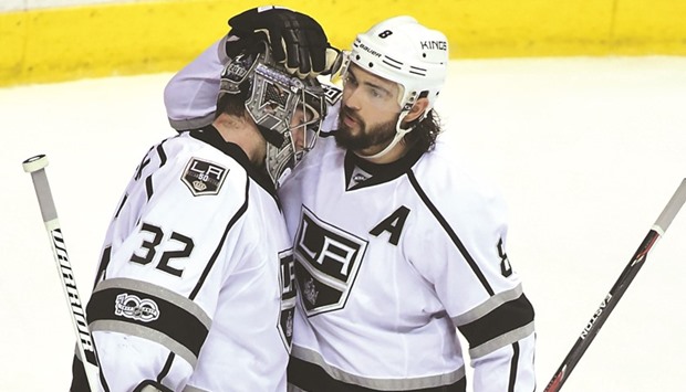 Los Angeles Kings defenseman Drew Doughty (R) congratulates goaltender Jonathan Quick (32) for the win.