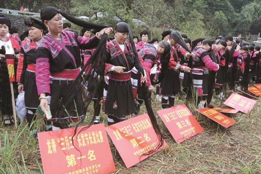 Ethnic Yao minority women brush their long hair as part of a performance during the local Long Hair Festival, to celebrate the third day of the third lunar month which is regarded as a traditional festival for many ethnic minorities in Guilin, Guangxi Zhuang Autonomous Region, China.