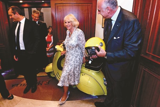 The Duchess of Cornwall, Camilla, poses before a yellow vespa during her visit to Marinella, in Naples. Britainu2019s Prince Charles and Duchess of Cornwall are doing a European tour aimed at strengthening relations with EU allies post Brexit.
