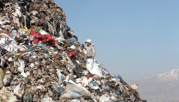 Boys sift through garbage at a dump near a makeshift settlement for Syrian refugees in Bar Elias town, in the Bekaa valley, Lebanon.