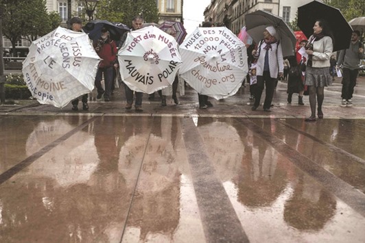 People hold umbrellas with inscriptions that translate into u2018Museum of textiles, letu2019s protect our heritageu2019, u2018death of a museumu2019, and u201cMuseem of textiles, 120,000 petitions, say no to the closureu2019 during a demonstration yesterday in Lyon against the closure project of Musee des Tissus (Museum of Textiles). Participants were asked to come with an umbrella decorated with pieces of textile.