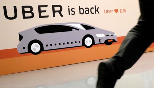 A man walks past a poster for Uber during a press conference in Taipei on Thursday.