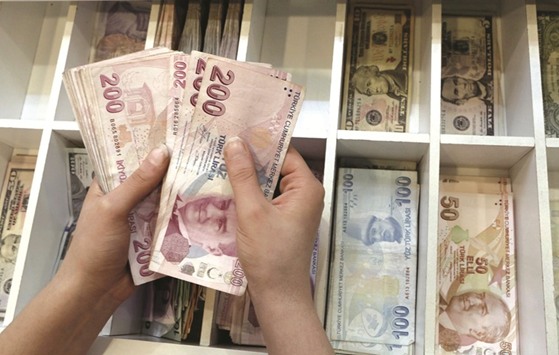 A money changer counts Turkish lira bills at a currency exchange office in central Istanbul. The lira is one of the few emerging currencies to have weakened against the dollar this year.