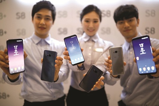 Models pose with Samsung Electronicsu2019 Galaxy S8 smartphones during a media event at a companyu2019s building in Seoul. The new smartphone has received favourable reviews ahead of the start of sales in South Korea, the US and Canada on April 21. Some investors and analysts have even predicted a first-year sales record for the South Korean company.