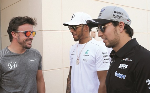 Mercedesu2019 driver Lewis Hamilton (C) speaks with McLaren Hondau2019s driver Fernando Alonso (L) and Force Indiau2019s driver Sergio Perez (R) during a practise session in Manama yesterday. (AFP)