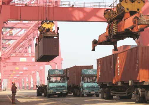 A worker looks on as trucks transport shipping containers at a port in Lianyungang, east Chinau2019s Jiangsu province. Chinese exports surged 16.4% year-on-year to $180.6bn in March, official data showed yesterday.