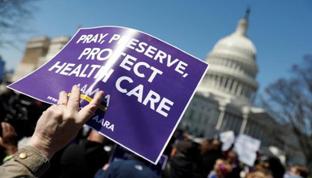 Demonstrators hold signs during a protest against the repeal of the Affordable Care Act outside the Capitol Building in Washington, U.S.