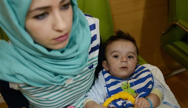 Iraqi mother Gufran Ali holds her son Karam at a hospital in Noida on Friday.