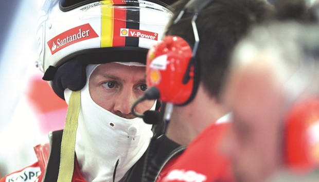 Ferrariu2019s German driver Sebastian Vettel talks to one of his engineers in the garage at the Sakhir circuit in Bahrain yesterday.