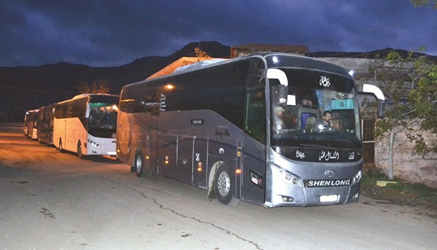 Buses carrying Syrian evacuees are seen in the rebel-held town of Madaya leaving under a evacuation deal, yesterday.