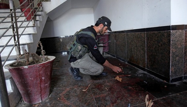 A policeman searches for evidence at the dorm where Mashal Khan, accused of blasphemy, was killed by a mob at Abdul Wali Khan University in Mardan.