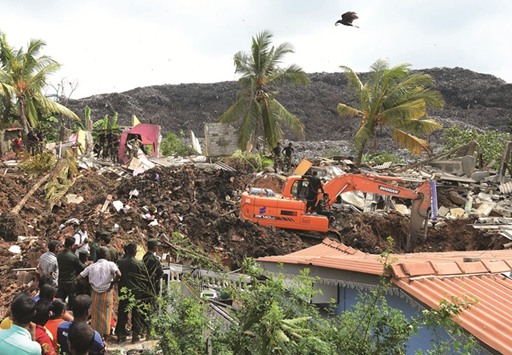 Military rescue workers carry out a rescue operation at the site of a collapsed garbage dump in Colombo yesterday.