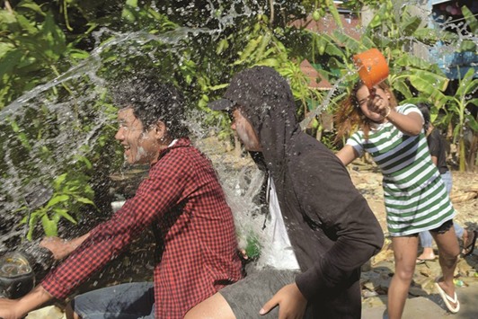 A woman throws water at a motorcyclist and his passenger during celebrations to mark the Khmer New Year in Phnom Penh on Friday.