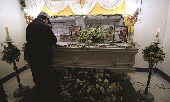 File photo shows a mourner standing by the coffin of a man killed in an anti-drug operation.